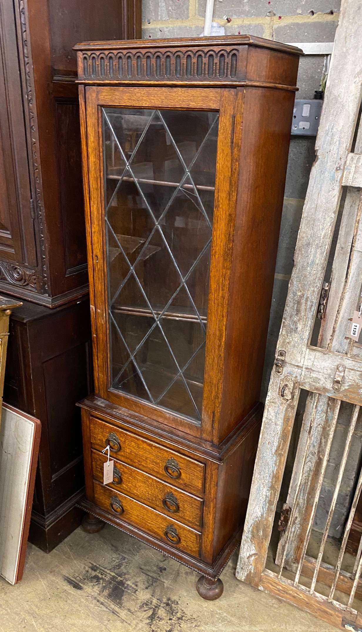 A 1920's narrow oak leaded glazed bookcase, width 52cm, depth 32cm, height 151cm
